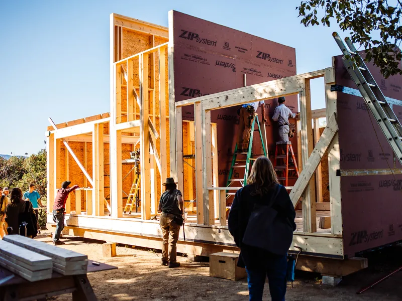 Wide shot of a partially framed building with students in the foreground.