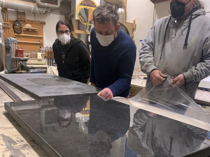 Students observe a concrete countertop being unpeeled