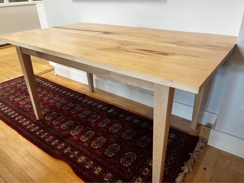 A rectangular maple dining table large enough for 4-6 people. 