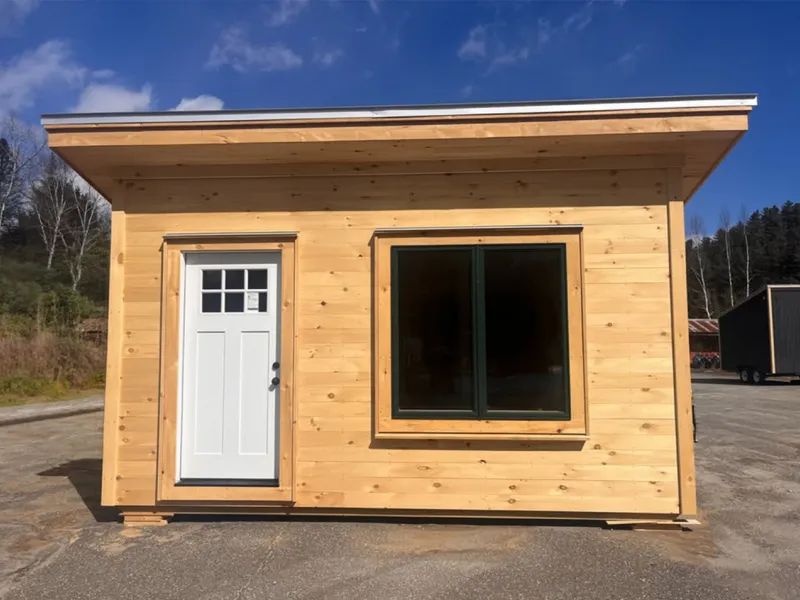 The exterior of a simple cabin sided with pine ship lap. 