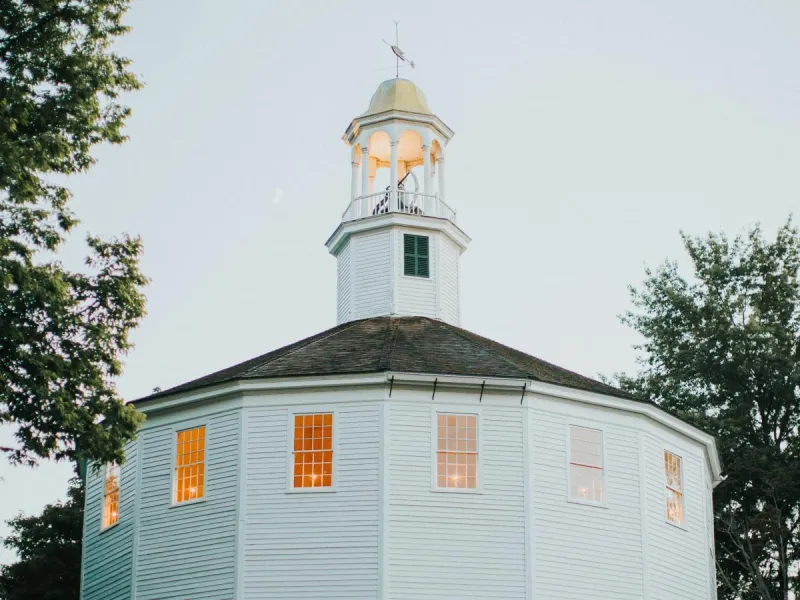 Photo of the round church, a white mulitfaceted building with tall spire.