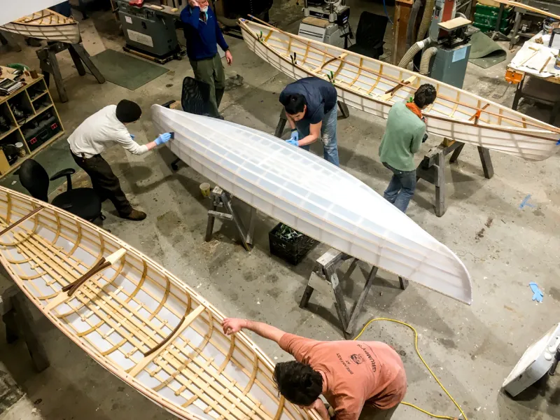 An aerial photo of 3 canoes being built.