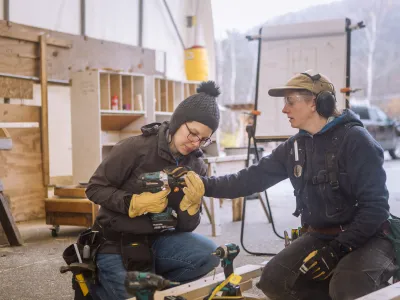 An instructor shows a student how to use a driver.