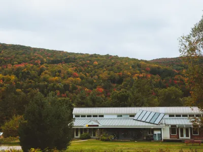 A wide shot of the main building with fall foliage hillsides in the background.