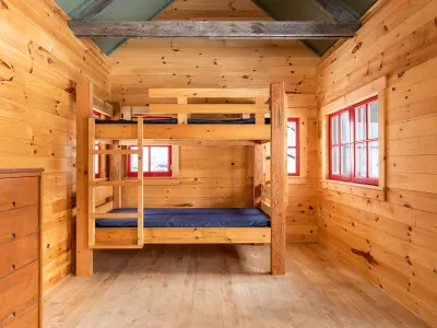 Interior shot of the slate cabin with wood paneling inside and two bunk beds.