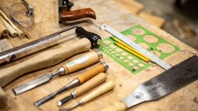 An array of woodworking tools pictured on a work bench.