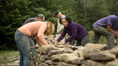 Students building a rock wall.