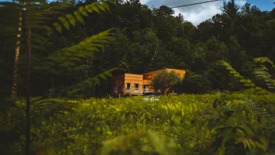 wide shot of the meadow with bunkhouse and hillside in the background.