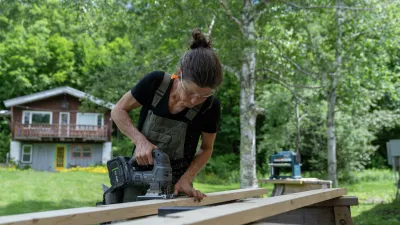 A carpentry student uses a circular saw to cut a piece of lumber.