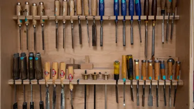A wall cabinet full of chisels. 