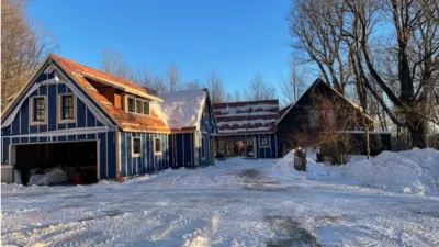 Wide shot of a house undergoing renovation in the winter with snow on the ground