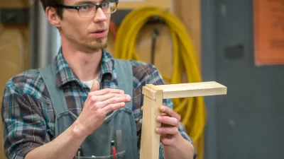 A photo of an instructor demonstrating dovetail joinery. 