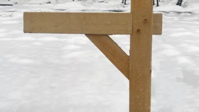A wooden mailbox post in a snowy field. 