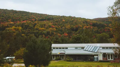 A wide shot of the main building with fall foliage hillsides in the background.