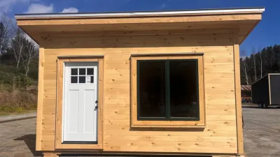 The exterior of a simple cabin sided with pine ship lap. 