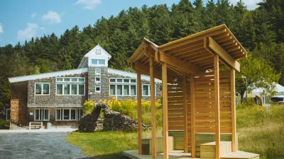 A bus stop sits in the foreground with the main building in the background