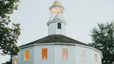 Photo of the round church, a white mulitfaceted building with tall spire.