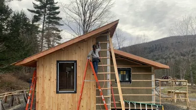 Casa virga is pictured with a student on a ladder working on installing siding