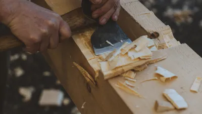 Close up shot of someone using an axe to cut a timber joint.