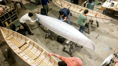 An aerial photo of 3 canoes being built.