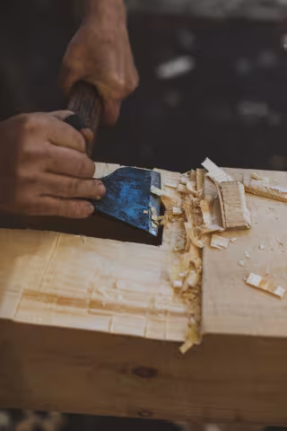 Detail shot of cutting a timber with a small axe.