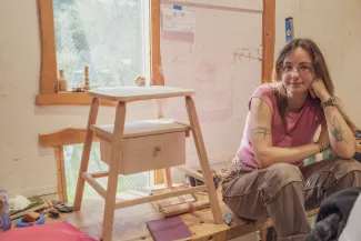Sophie sitting next to a stool she made