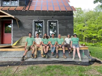 Brian Cali and friends smile in front of his home.