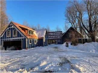 Wide shot of a house undergoing renovation in the winter with snow on the ground
