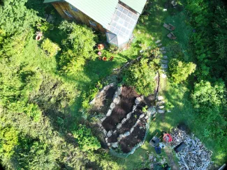 Aerial view of a home with a garden patch and lawn