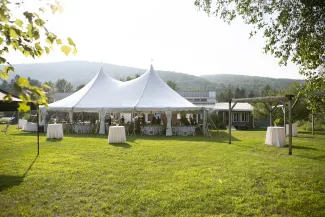 Wide shot of the campus lawn with large white celebration tent