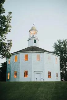 Photo of the round church, a white mulitfaceted building with tall spire.