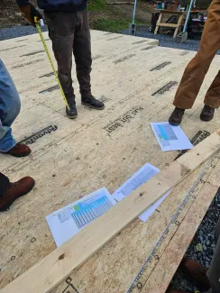 Plans for the house are photographed on the floor deck of the home outside