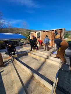 Semester students pictured inside the house with floor deck and one wall raised