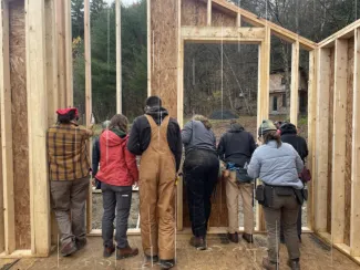 Semester students pictured from behind raising the east wall