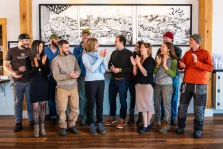 Yestermorrow staff poses at Lawsons receiving a sunshine fund grant. People in the group are laughing, smiling, and looking at each other.