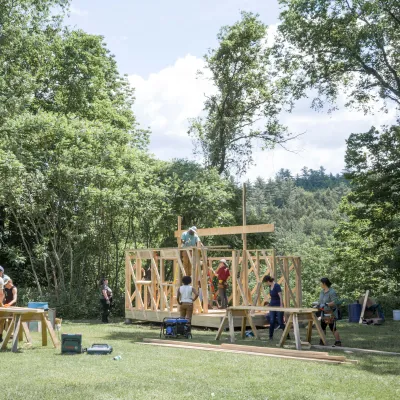 Wide shot of a partially framed building with students in the foreground.