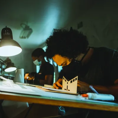 Students make models at drafting tables in the main studio