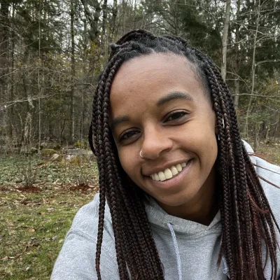 Women with Long braids takes a selfie in a forest.