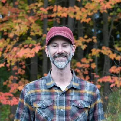 Patrick headshot with trees behind him