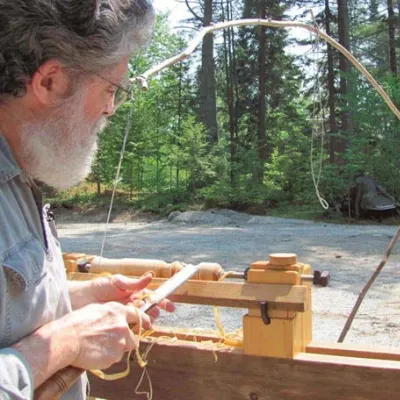 Richard, pictured from behind, turns on a lathe.