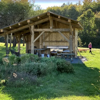 A timber framed outdoor kitchen is pictured in a field.