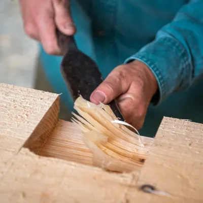 Timber framing detail shot of chiseling a mortise.