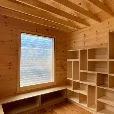 Interior shot of finished tiny library with shelving and wooden benches.