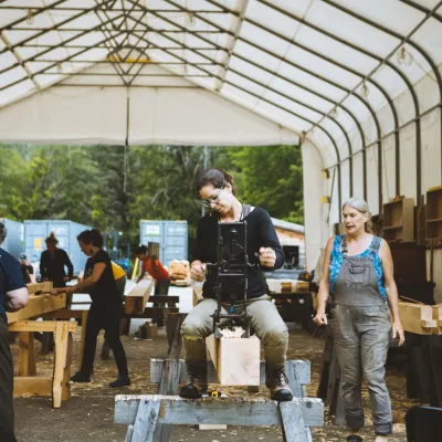 A student uses a hand borer to cut peg holes in a timber