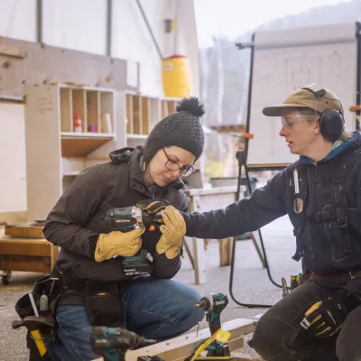 An instructor shows a student how to use a driver.