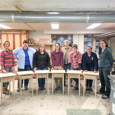 A group of students poses for a class photo with their end tables.