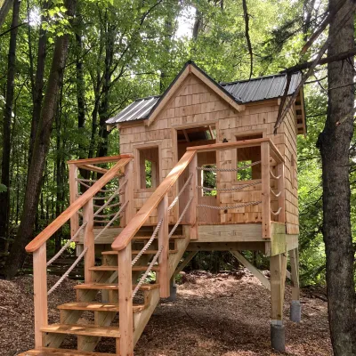 A shingled playstructure in the woods