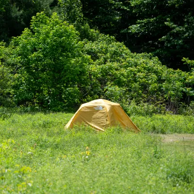 Yellow camping tent in a field