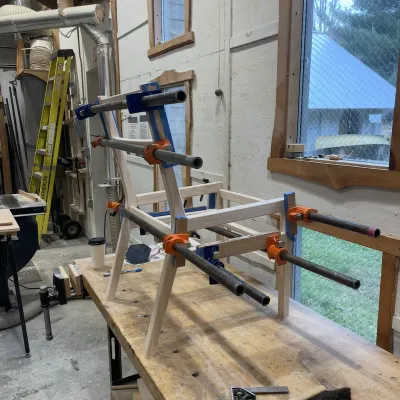 A chair gets glued up between clamps in the woodshop
