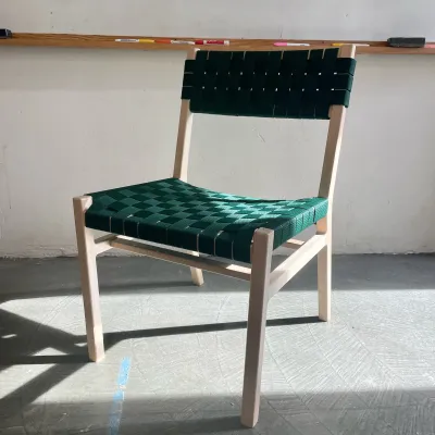 Photo of a maple chair with forest green woven seat and back in a bright classroom
